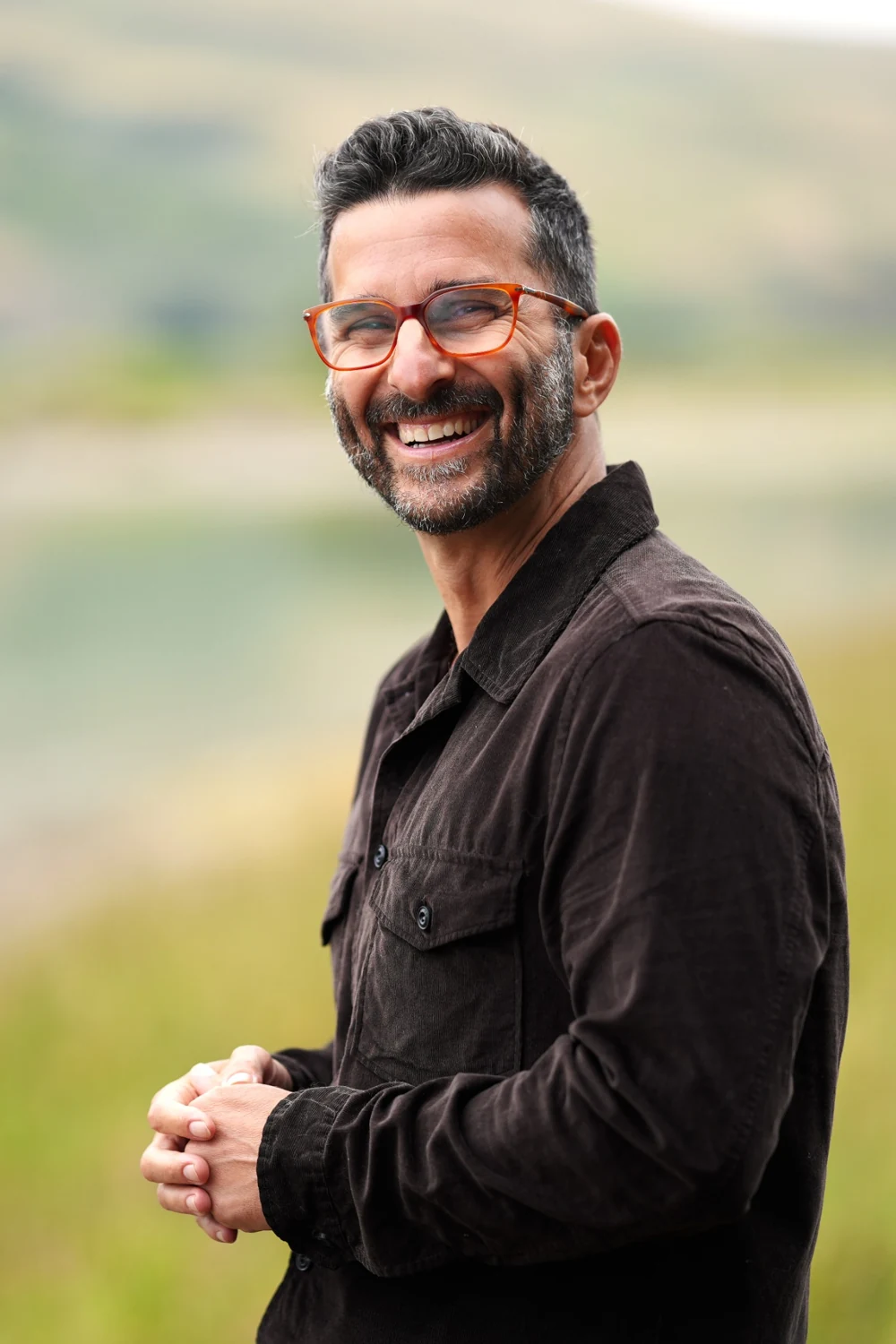 Zev Schiller laughing, wearing orange glasses
