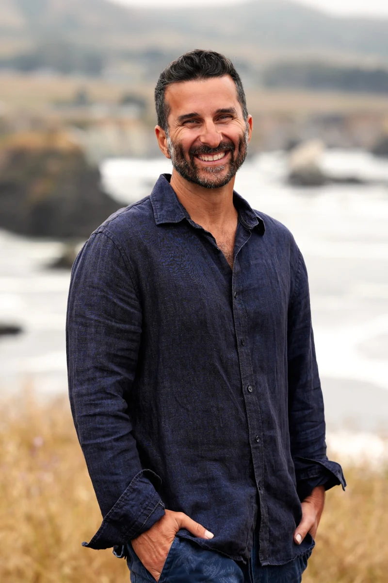 Zev Schiller smiling by the coast